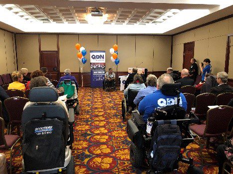 Around 50 people in a room looking a the front where Will is speaking.