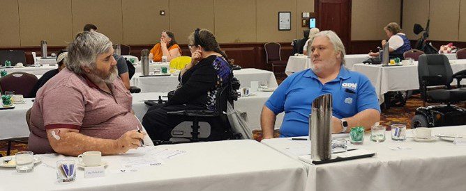 Two men sitting at a table having a discussion. 