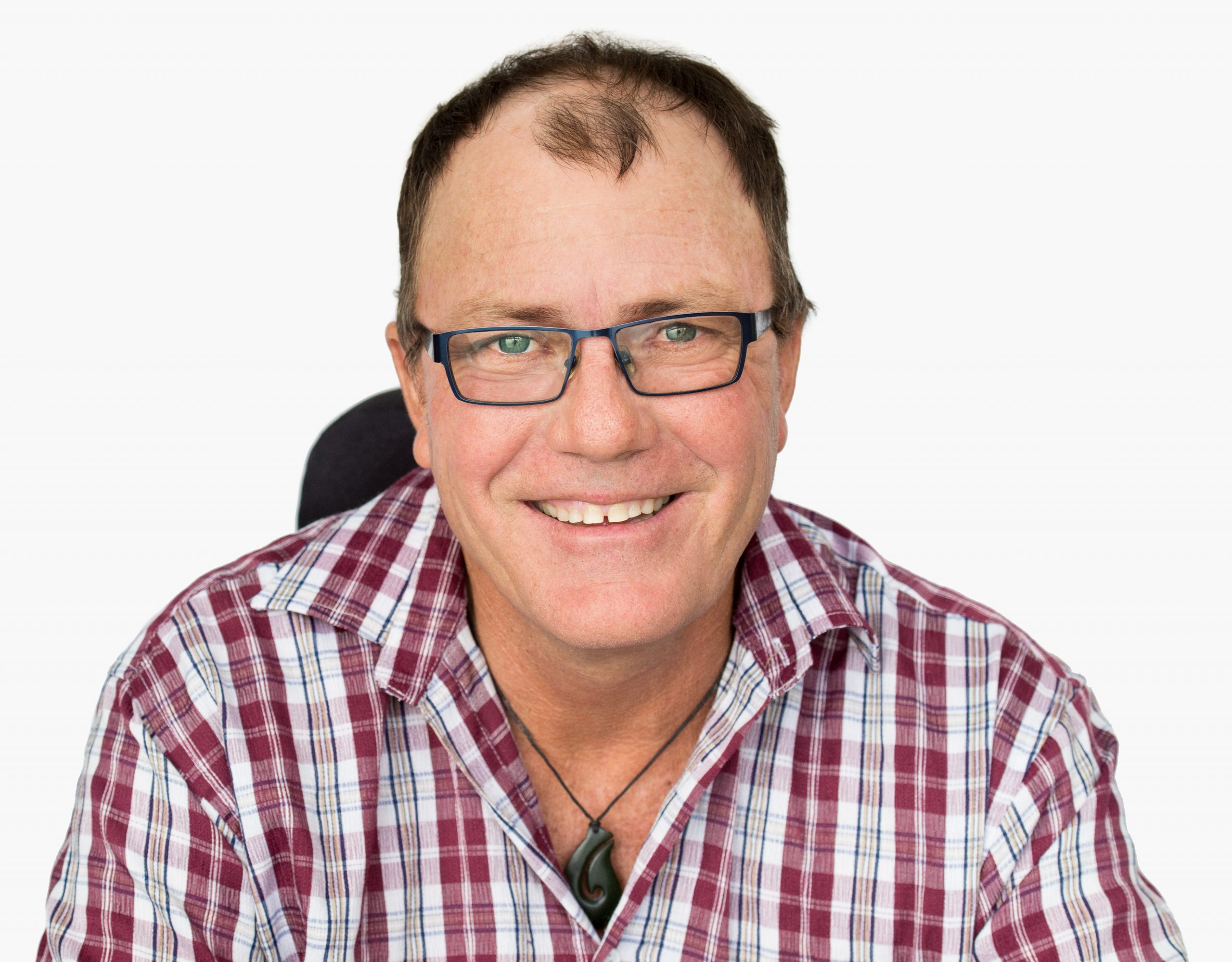 man with glasses and a checkered shirt smiling at camera