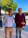 Two men standing looking at camera. They are outside.