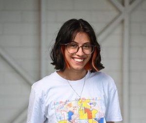 Young Woman with a pair if jeans and white T-shirt smiling to a camera.