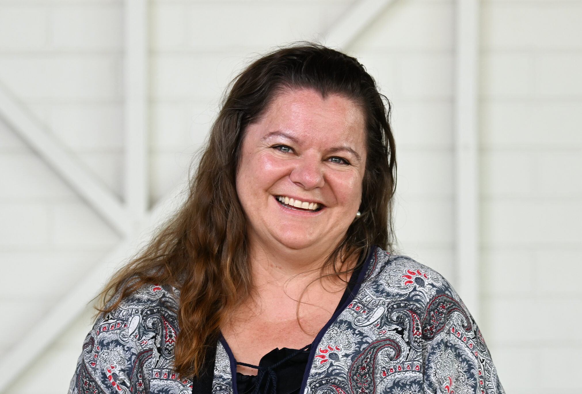 Portrait of a smiling woman sitting in a wheelchair, looking directly at the camera.